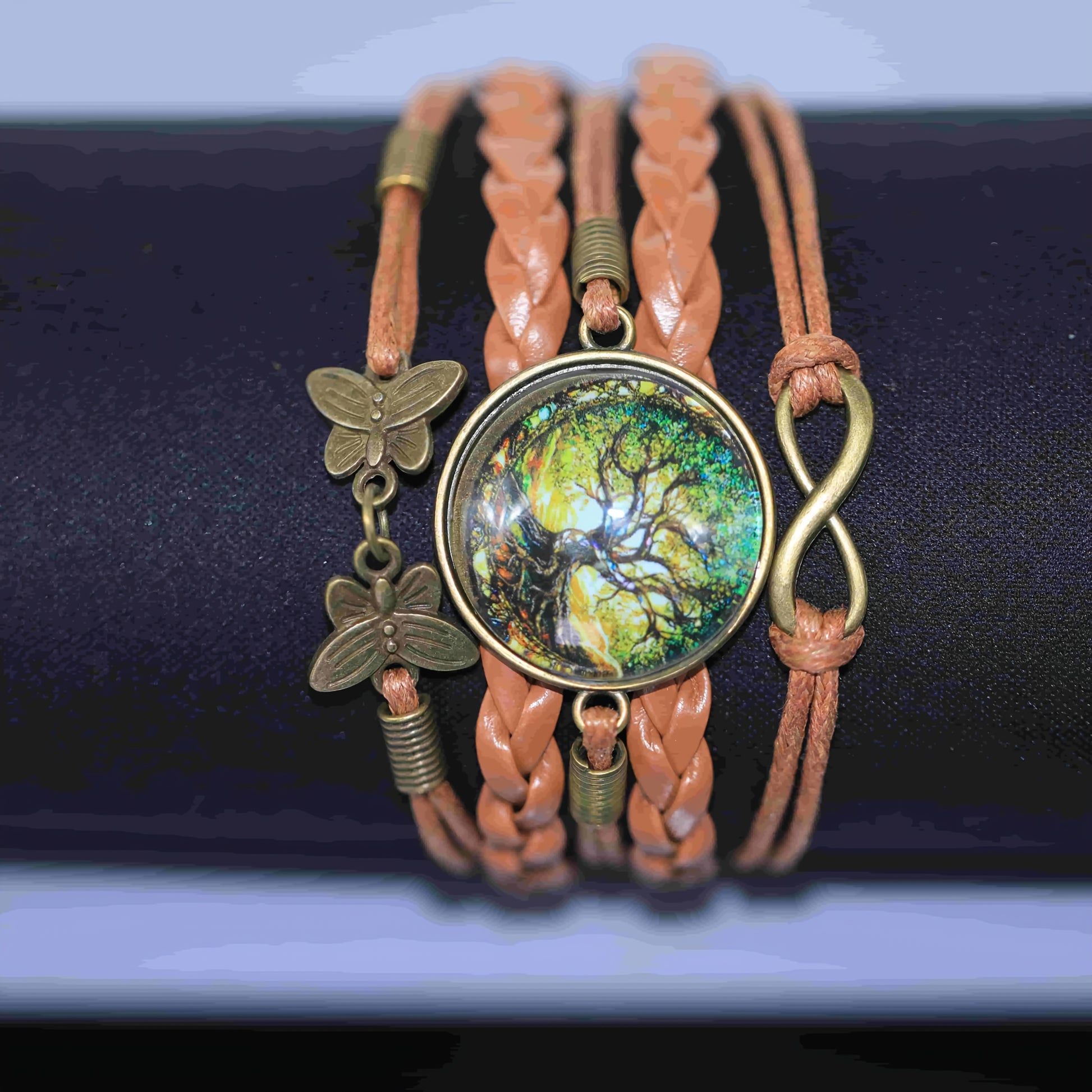 Bracelet with tree of life pendant and butterfly charms on a dark background